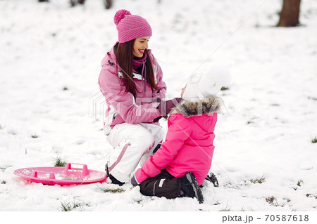 Mother and child in winter clothes play in winter park 70587618