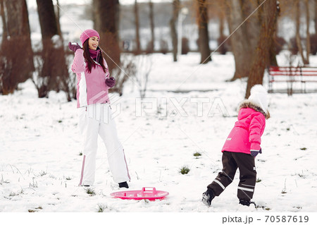 Mother and child in winter clothes play in winter park 70587619