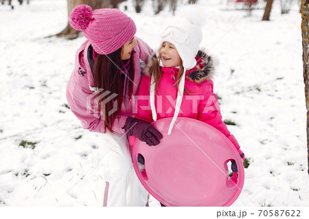 Mother and child in winter clothes play in winter park 70587622