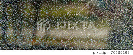 The geometry of the cracking glass. Glass breaking symmetry. The glass surface. White and green colors. Suitable as natural background. Free space for message The geometry of the cracking glass. Glass breaking symmetry. The glass surface. White and green colors. Suitable as natural background. Free space for message 70589195