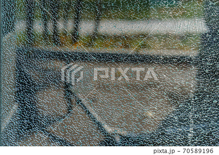 The geometry of the cracking glass. Glass breaking symmetry. The glass surface. White and green colors. Suitable as natural background. Free space for message The geometry of the cracking glass. Glass breaking symmetry. The glass surface. White and green colors. Suitable as natural background. Free space for message 70589196