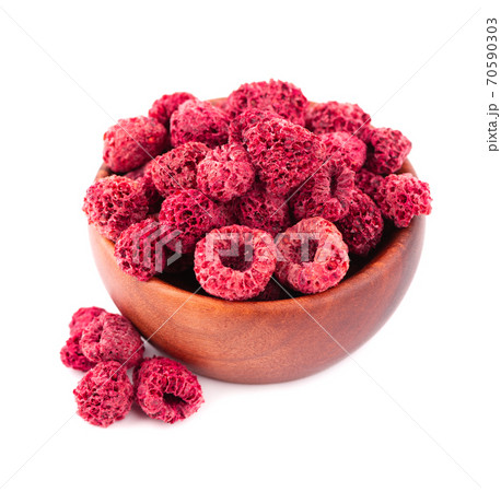 Dried raspberry isolated on white background. Dehydrated raspberry in wooden bowl. Dried raspberry isolated on white background. Dehydrated raspberry in wooden bowl. 70590303