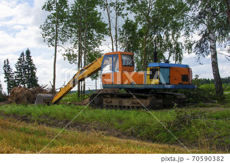 The excavator uproots trees to expand agricultural fields. The bulldozer harms the environment as a result of human activity. Ecology problem. The excavator uproots trees to expand agricultural fields. The bulldozer harms the environment as a result of human activity. Ecology problem. 70590382