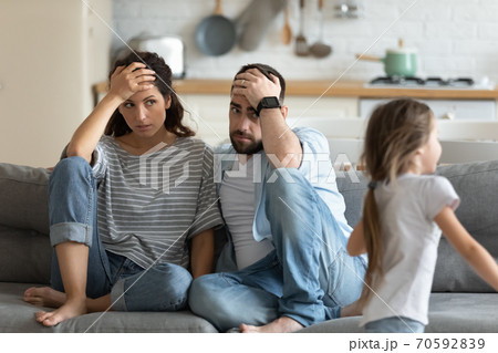 Tired mother and father having problem with noisy naughty daughter 70592839