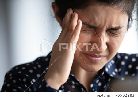 Closeup view frown face of indian woman feeling strong headache 70592883