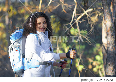 Smiling African American woman walking through the forest. Smiling African American woman walking through the forest. 70593578