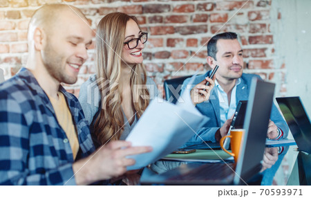 Businesspeople in startup company looking at graphs and figures Businesspeople in startup company looking at graphs and figures 70593971