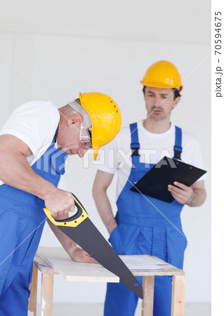 Builders in hardhats with tools Builders in hardhats with tools 70594675
