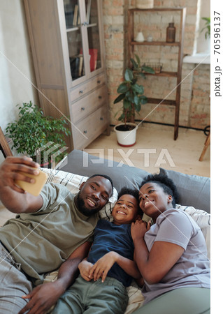 Joyful young family of affectionate parents and their little son making selfie 70596137