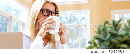 Happy young woman drinking coffee 70596314