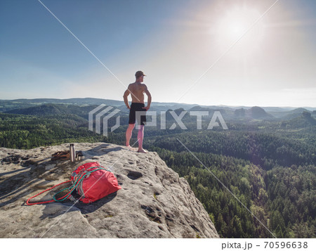 Half naked man holds his hands on his hips and watc Half naked man holds his hands on his hips and watc 70596638