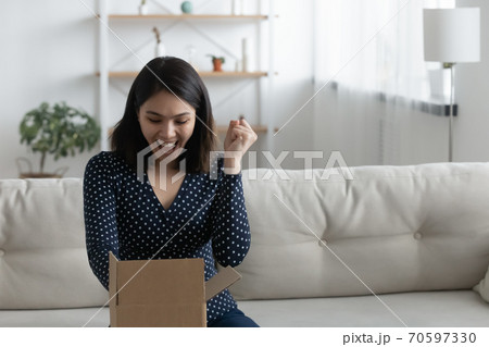 Excited asian woman triumph with internet order Excited asian woman triumph with internet order 70597330