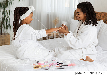 Manicure Time. Loving Black Mom Painting Nails To Her Cute Little Daughter 70598476