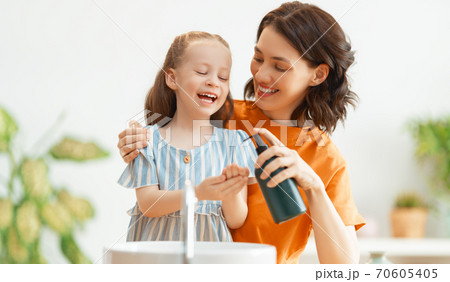 girl and her mother are washing hands girl and her mother are washing hands 70605405