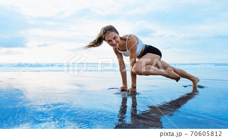 Sporty woman doing mountain climber exercise - run in plank position Sporty woman doing mountain climber exercise - run in plank position 70605812
