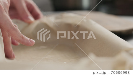 man hand spread oil in container with baking paper 70606998
