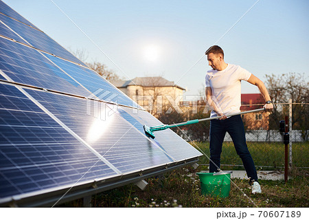 Young man cleaning solar panel Young man cleaning solar panel 70607189