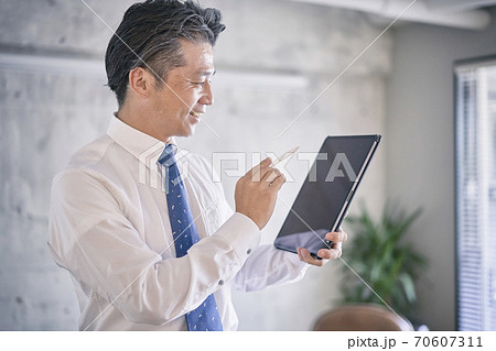 ビジネスシーン　タブレットを使う男性 70607311
