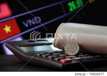 Two hundred Vietnam Dong coin on reverse (VND) on black calculator and wallet with digital board Two hundred Vietnam Dong coin on reverse (VND) on black calculator and wallet with digital board 70608277