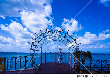 沖縄観光で青空と海を背景に立つ女性の写真素材