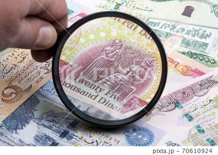 Iraqi dinar in a magnifying glass 70610924