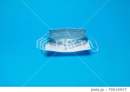 Disposable blue medical face mask on blue background Disposable blue medical face mask on blue background 70610937