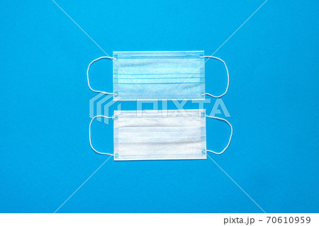 Disposable blue medical face masks on blue background Disposable blue medical face masks on blue background 70610959