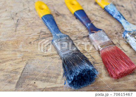 Used paint brushes on a wooden background 70615467
