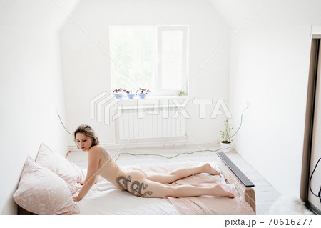 sexy girl with tattoo. Nude woman lying on bed sexy girl with tattoo. Nude woman lying on bed 70616277