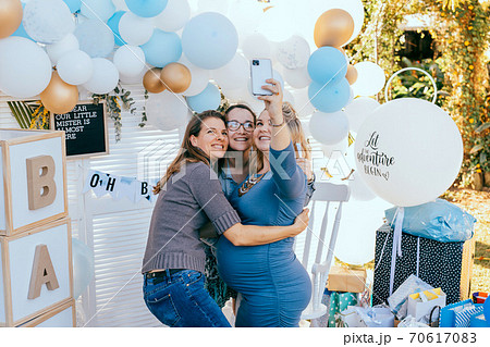 Female friends taking selfie with pregnant woman at a baby shower Female friends taking selfie with pregnant woman at a baby shower 70617083