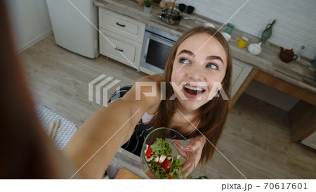 POV shot of blogger girl making photos and taking selfies for social media on smartphone at kitchen POV shot of blogger girl making photos and taking selfies for social media on smartphone at kitchen 70617601