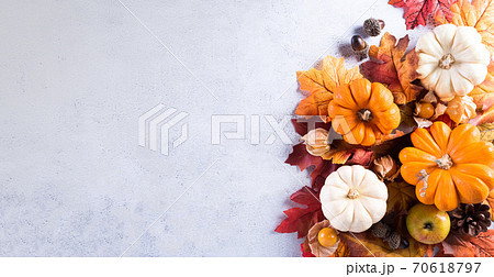 Thanksgiving background decoration from dry leaves and pumpkin on  gray stone background. Flat lay, top view with copy space. 70618797
