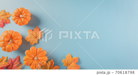 Thanksgiving background decoration from dry leaves and pumpkin on  pastel blue background. Flat lay, top view with copy space. 70618798