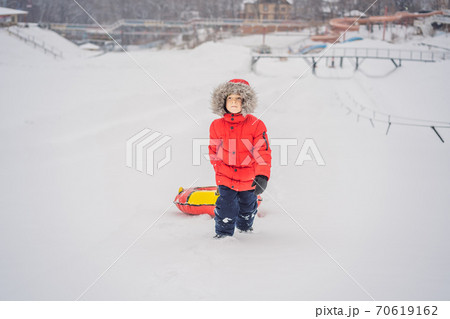 Child having fun on snow tube. Boy is riding a tubing. Winter fun for children Child having fun on snow tube. Boy is riding a tubing. Winter fun for children 70619162