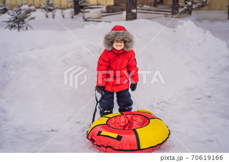 Child having fun on snow tube. Boy is riding a tubing. Winter fun for children Child having fun on snow tube. Boy is riding a tubing. Winter fun for children 70619166