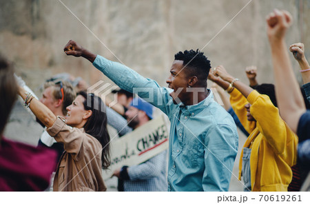 Group of people activists with raised fists protesting on streets, BLM demonstration concept. Group of people activists with raised fists protesting on streets, BLM demonstration concept. 70619261