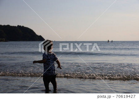 夏の江ノ島の波打ち際で遊ぶ小さい子供の写真素材