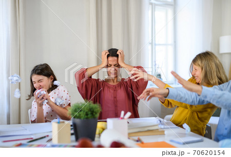 Group of misbehaving homeschooling children with teacher studying indoors, coronavirus concept. 70620154