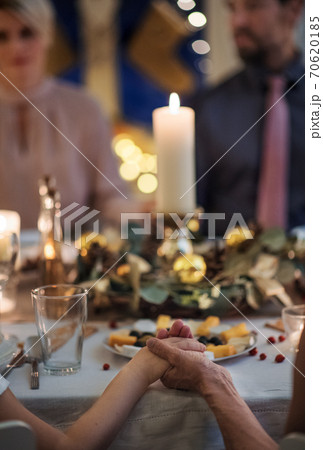 Close-up of hands holding together at the table at Christmas. Close-up of hands holding together at the table at Christmas. 70620185