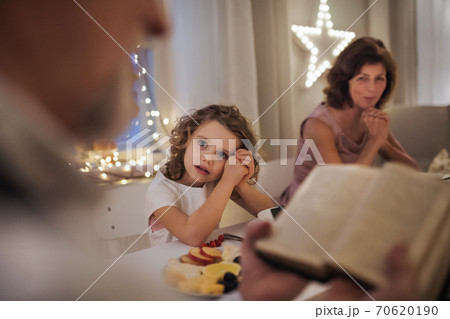 Small girl with parents and grandparents indoors celebrating Christmas. 70620190