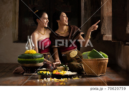 Two thai woman in traditional dress costume making and decorating Krathong. Loy Krathong Festival. 70620759