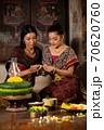 Two thai woman in traditional dress costume making and decorating Krathong. Loy Krathong Festival. 70620760