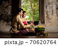 Thai couple in traditional dress costume making and decorating Krathong. Loy Krathong Festival. 70620764