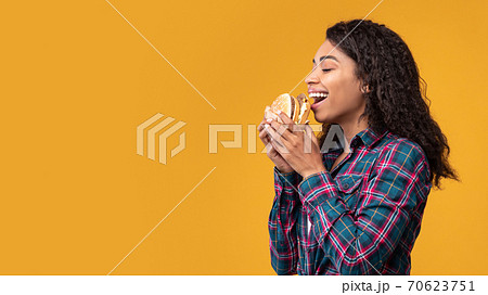 Portrait Of African American Lady Eating Burger At Studio 70623751