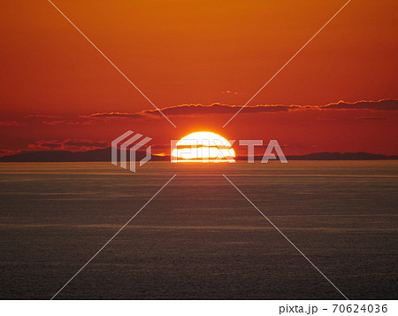 鳥ヶ首岬灯台付近、水平線に沈みかけている夕日 新潟県上越市 70624036