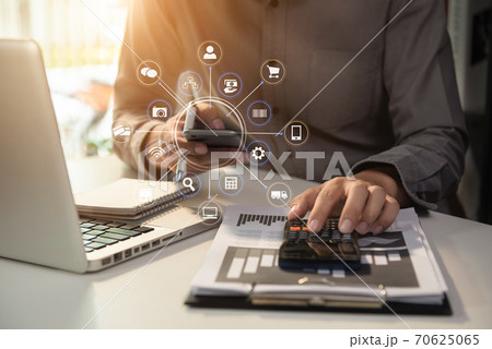 businessman calculates financials with graph paper on the laptop computer, cell phone on the cost of home office. businessman calculates financials with graph paper on the laptop computer, cell phone on the cost of home office. 70625065