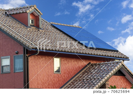 エコ住宅　洋風屋根と太陽光パネルと青空 70625694