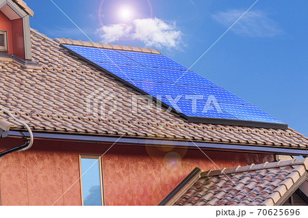 エコ住宅　洋風屋根と太陽光パネルと青空 70625696