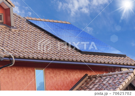 エコ住宅　洋風屋根と太陽光パネルと青空 70625702