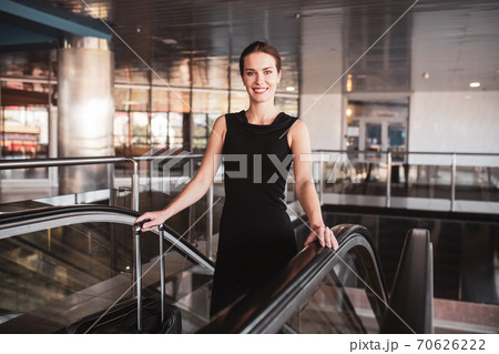 Elegant woman using an escalator in the airport Elegant woman using an escalator in the airport 70626222